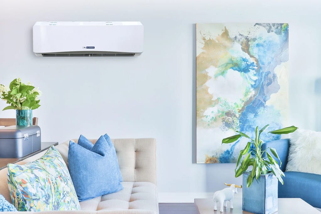 A blue-themed living room with a wall-mounted mini-split AC.